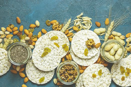 American puffed rice cakes. Healthy snacks with ears of wheat on classic blue concrete surface, top view, flat lay, copy space for you text.