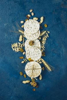 American puffed rice cakes. Healthy snacks with ears of wheat on classic blue concrete surface, top view, flat lay, copy space for you text.