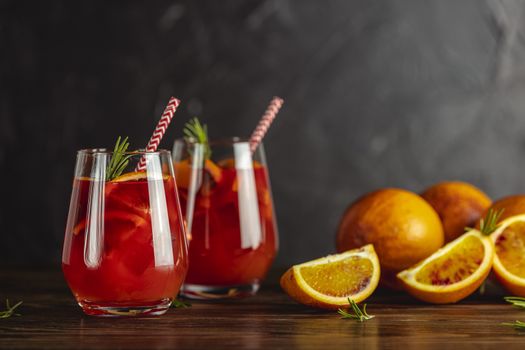 Two glasses of campari gin spritz. Cocktail of sweet, a touch of bitter from the campari and gorgeous fizz from the champagne topper. Dark background	