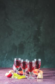 Plums strong alcoholic drink in vintage shots. Hard liquor, slivovica, plum brandy or plum vodka with ripe plums	