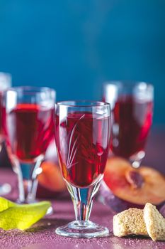 Plums strong alcoholic drink in vintage shots. Hard liquor, slivovica, plum brandy or plum vodka with ripe plums	