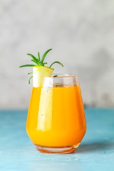 Yellow orange cocktail with melon and mint in glass on blue concrete background, close up. Summer drinks and alcoholic cocktails. Alcoholic or detox cocktail