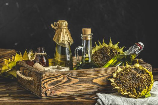 Organic sunflower oil in a small glass jars with sunflower seeds. Closeup photo of sunflower oil with seeds on wooden background. Bio and organic product concept.