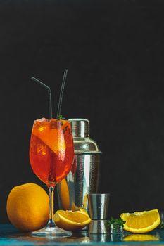 Cocktail aperol spritz in big wine glass with water drops on dark background. Summer alcohol cocktail with orange slices.	