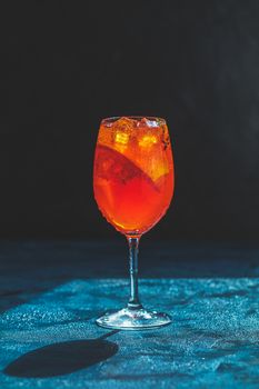 Cocktail aperol spritz on dark background.. Sunlight. Summer alcohol cocktail with orange slices. Italian cocktail aperol spritz on slate board. Trendy beverage.