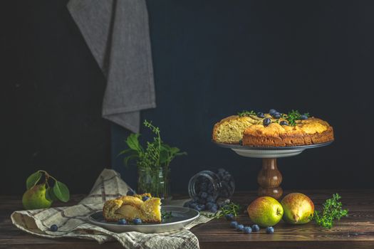 Delicious dessert blueberry tart with fresh berries and pears, sweet tasty cheesecake, berry pie. French cuisine Artistic Still Life in the style of Dutch painting. Copy space for you text