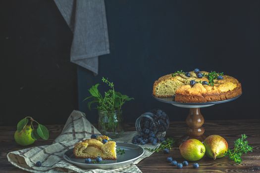 Delicious dessert blueberry tart with fresh berries and pears, sweet tasty cheesecake, berry pie. French cuisine Artistic Still Life in the style of Dutch painting. Copy space for you text