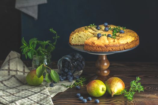 Delicious dessert blueberry tart with fresh berries and pears, sweet tasty cheesecake, berry pie. French cuisine Artistic Still Life in the style of Dutch painting. Copy space for you text