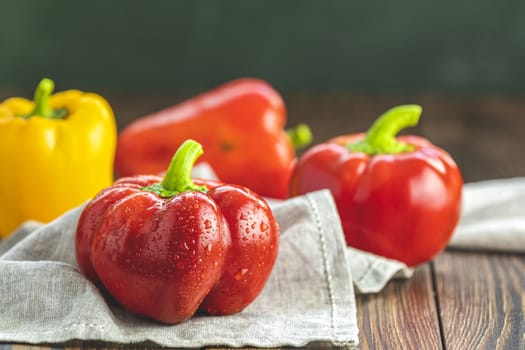 Ripe organic fresh sweet red and yellow pepper on dark wooden table. Selection of healthy food for heart, life concept