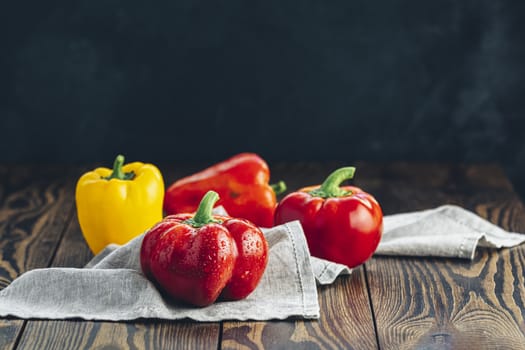 Ripe organic fresh sweet red and yellow pepper on dark wooden table. Selection of healthy food for heart, life concept
