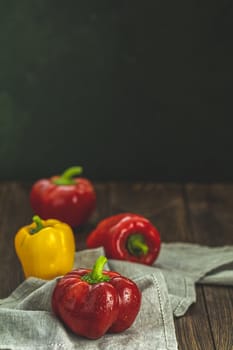 Ripe organic fresh sweet red and yellow pepper on dark wooden table. Selection of healthy food for heart, life concept