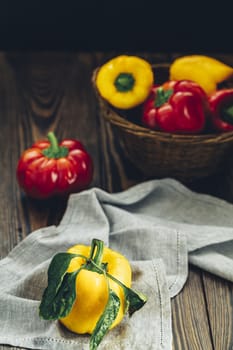 Ripe organic fresh sweet red and yellow pepper on dark wooden table. Selection of healthy food for heart, life concept