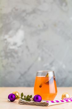 Christmas and New Year pink cocktail with fig and cinnamon  in glass on pink concrete background, close up, surrounded  holiday decor. Winter festive drinks and alcoholic cocktails or detox drink