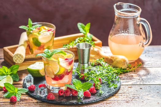 Refreshing mint cocktail mojito with rum, lime and raspberry, cold drink or beverage