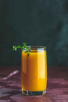 Glass of fresh healthy peach smoothie or juice on dark concrete surface table. Shallow depth of the field, close up, copy space for you text