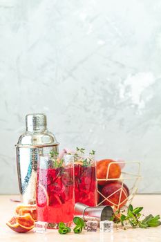 Cocktail bloody orange margarita in highball glass. Refreshing summer drinks. Cocktail blood orange margarita, in glasses on a pink concrete table surface with a garnish of orange. Copy space.