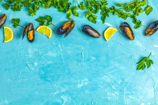 Seafood mussels with lemon and parsley on light blue concrete table surface, top view, copy space for you text