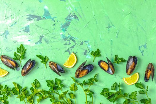 Seafood mussels with lemon and parsley on green concrete table surface, top view, copy space for you text, food background
