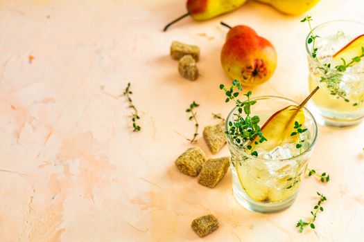 Cold pear white tea with thyme on the wooden background. Summer drinks, thyme pear cocktails. Selective focus, space for text