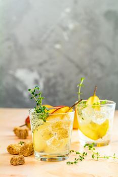 Cold pear white tea with thyme on the wooden background. Summer drinks, thyme pear cocktails. Selective focus, space for text