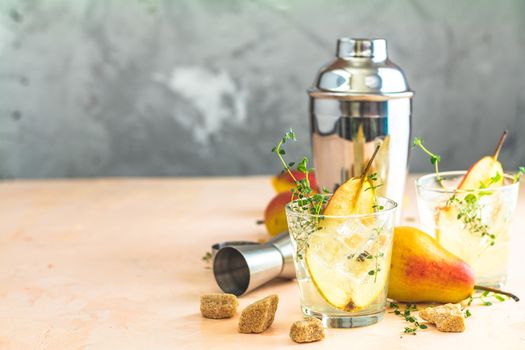 Cold pear white tea with thyme on the wooden background. Festive summer drinks, pear thyme cocktail. Selective focus, space for text