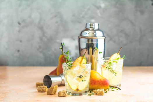 Pear mulled cider with thyme, brown sugar and ice on light concrete surface table