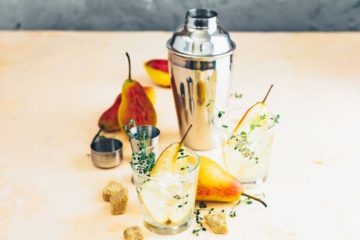 Pear mulled cider with thyme, brown sugar and ice on light concrete surface table