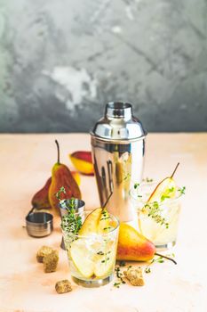 Cold pear white tea with thyme on the wooden background. Festive summer drinks, pear thyme cocktail. Selective focus, space for text