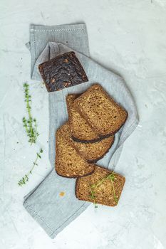 Whole wheat bread baked at home, bio ingredients, very healthy with seed on light gray concrete table surface, top view.