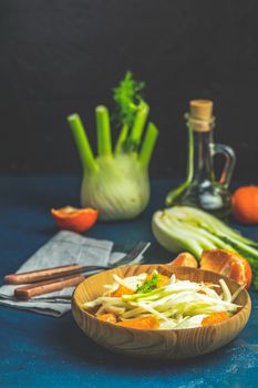 Traditional sicilian italian salad with fennel and tangerine. Fennel and orange citrus salad, on wooden plate. Modern, light, raw, veg cuisine. Winter salad.