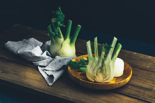 Fresh Florence fennel bulbs or Fennel bulb in plate on wooden background. Healthy and benefits of Florence fennel bulbs 