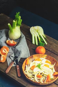 Traditional sicilian italian salad with fennel and tangerine. Fennel and orange citrus salad, on wooden plate. Modern, light, raw, veg cuisine. Winter salad.