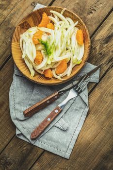 Traditional sicilian italian salad with fennel and tangerine. Fennel and orange citrus salad, on wooden plate. Modern, light, raw, veg cuisine. Winter salad.