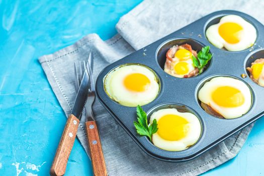 Baked eggs  in baking molds. Portioned casserole from bacon sowbelly and eggs in Italian style.