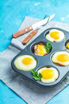 Baked eggs  in baking molds. Portioned casserole from bacon sowbelly and eggs in Italian style.