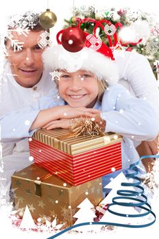 Portrait of a father and his son holding Christmas presents against snow falling