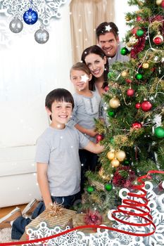 Happy family decorating a Christmas tree with boubles and presents against twinkling stars