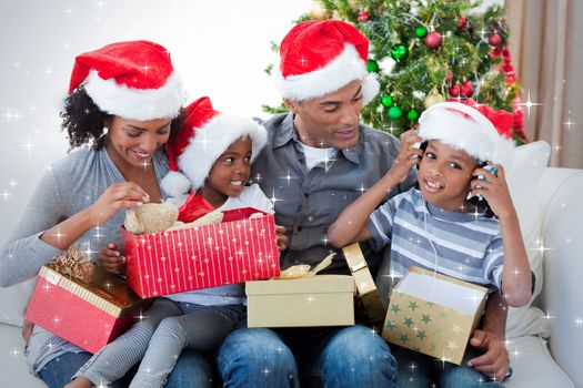 Happy family playing with Christmas presents against snow