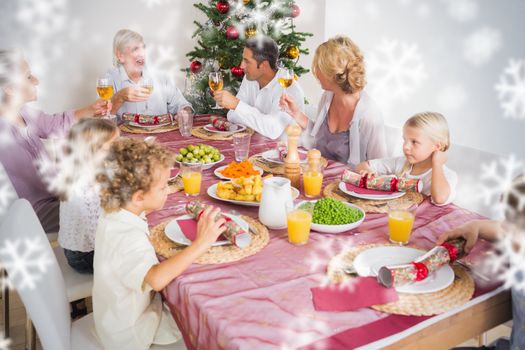 Composite image of Adults raising their glasses at christmas dinner against snowflakes