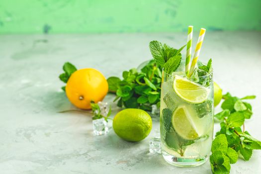 Mojito cocktail with lime and mint in highball glass on a gray and green concrete stone surface background. With copy space for your text