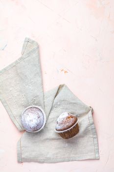 Tasty delicious homemade muffin on light pink living coral stone concrete surface, top view, copy space.