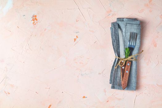 Rustic vintage set of cutlery knife, fork. Light pink living coral stone concrete surface background. Top view, copy space.