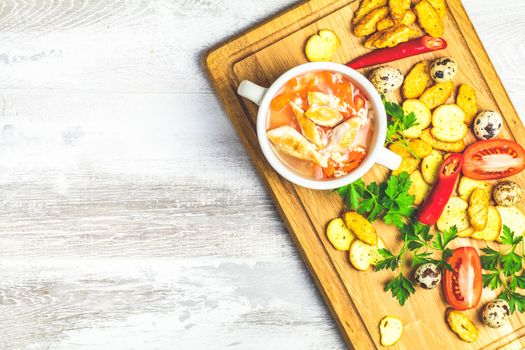 Concept of healthy vegetable and legume soups. Vegetables soup with carrot, eggs and chicken,  and ingredients. Top view on the background of a light gray wooden board, copy space