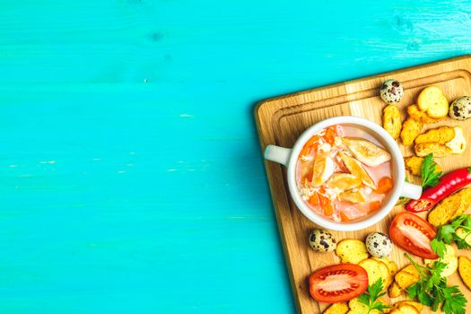 Concept of healthy vegetable and legume soups. Vegetables soup with carrot, eggs and chicken,  and ingredients. Top view on the background of a light gray wooden board, copy space