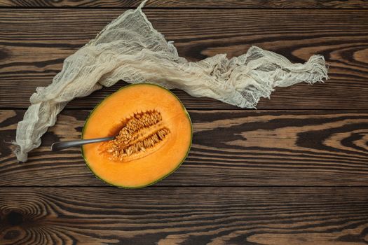 Organic cantaloupe melon slices siting on wooden cutting board with seeds. Top view, copy space, wooden background.