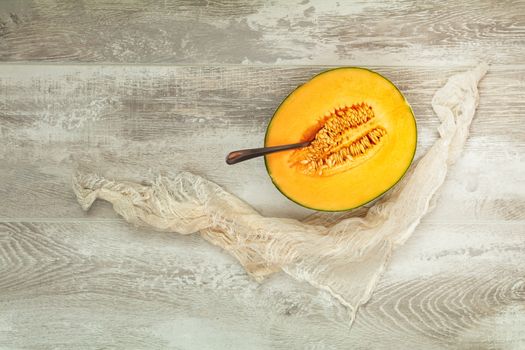 Organic cantaloupe melon slices siting on wooden cutting board with seeds. Top view, copy space, wooden background.