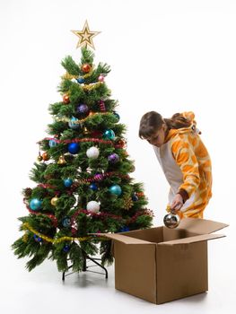 Girl puts Christmas decorations in a storage box