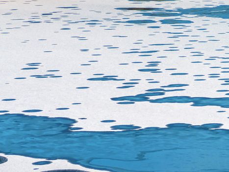 Winter white Landscape with ice and water circles. A frozen Manniku lake, snow texture close-up. Abstract shapes. Tallinn, Estonia. Panoramic view. Copy space for text. Image for wallpaper and desktop