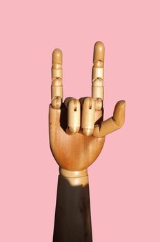 A hand of wood doll make love sign on pink background ,  Concept VALENTINE day  