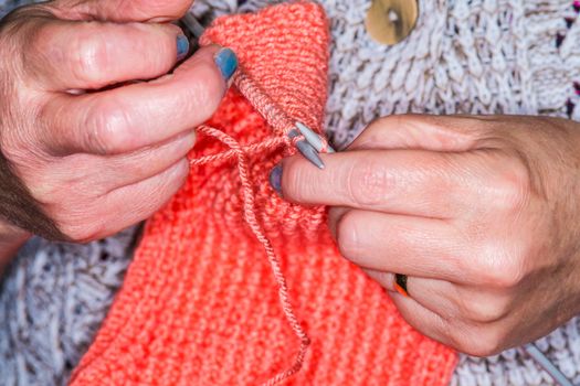 close up a woman knitting a jumper in UK